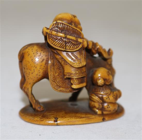 A Japanese stained ivory okimono netsuke of Hotei riding a deer, signed Tomochika, Meiji period, 4.1cm